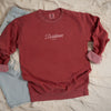 A Flat lay mockup of front design of crimson color sweatshirt with text design that partly reads 