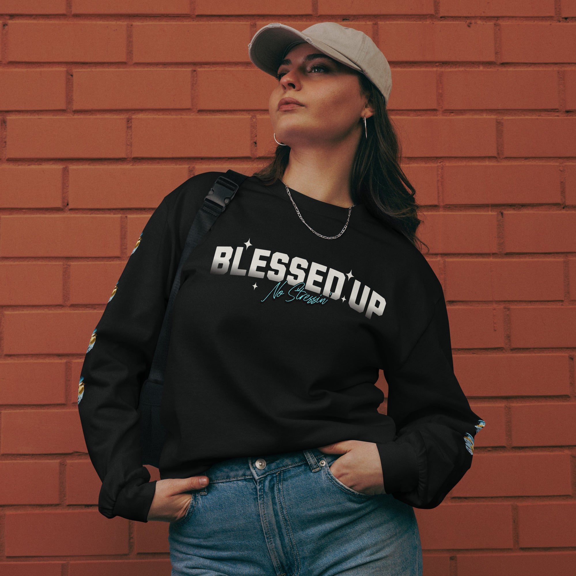 Lady wearing premium black heavyweight sweatshirt with text design saying Blessed Up No Stressin" across front chest area, also with intricate bible verse design on left and right sleeve